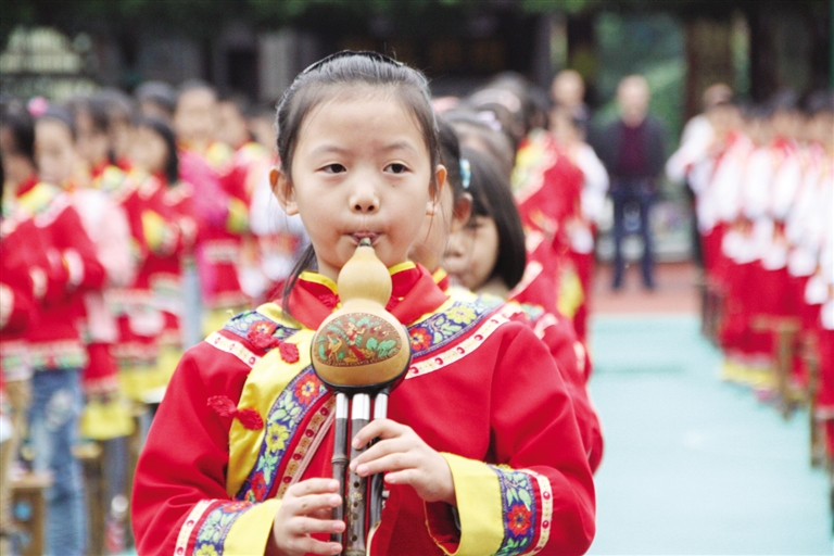 民族小学学生在吹葫芦丝